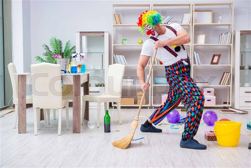 Funny clown doing cleaning at home, stock photo