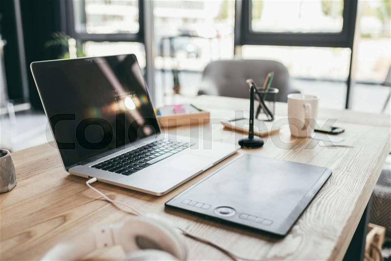 Close-up view of laptop and graphic tablet on table, stock photo