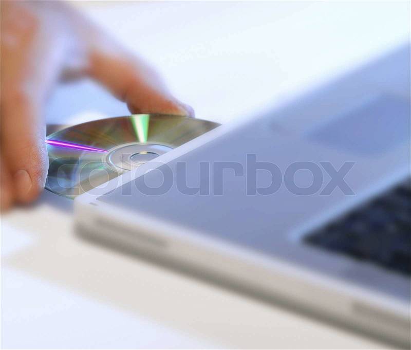 Laptop with CD in the tray, stock photo