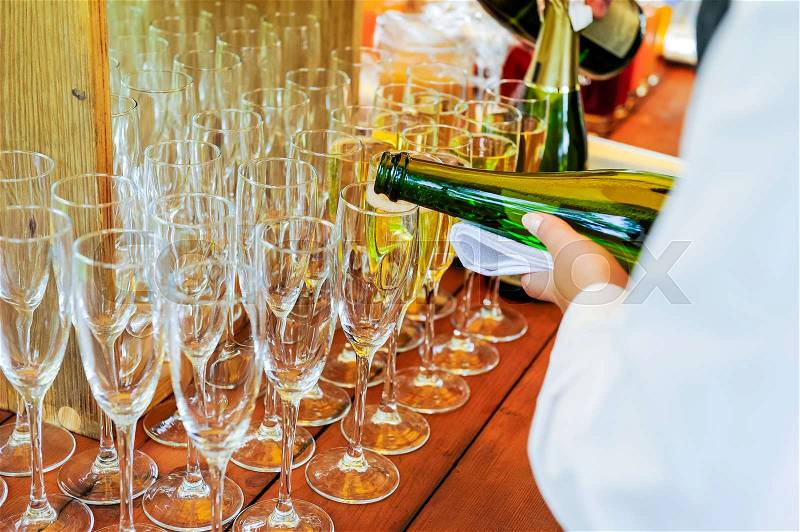 Waiter pouring personal serving Champagne in glasses. Catering service at events, corporate meeting, party, weddings. Selective focus, space for text, stock photo