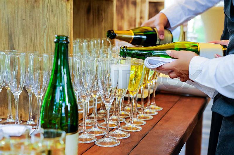 Waiter pouring personal serving Champagne in glasses. Catering service at events, corporate meeting, party, weddings. Selective focus, space for text, stock photo