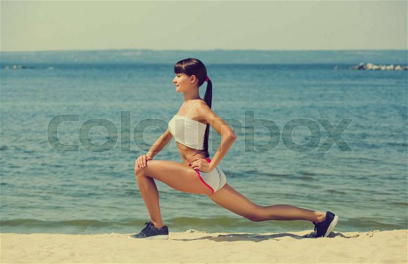 Young girl athlete, in shorts and top running on the beach in summer, morning exercise. Sports and healthy lifestyle, stock photo