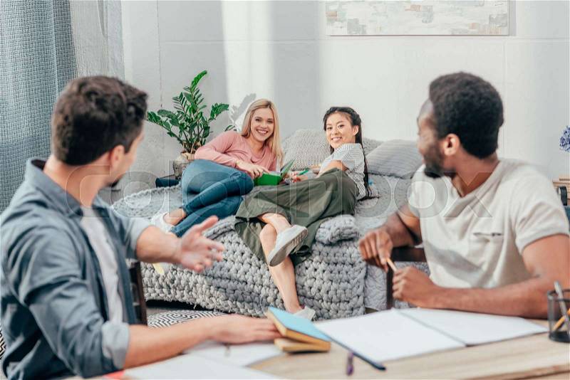 Group of young happy students studying at home in bedroom, stock photo