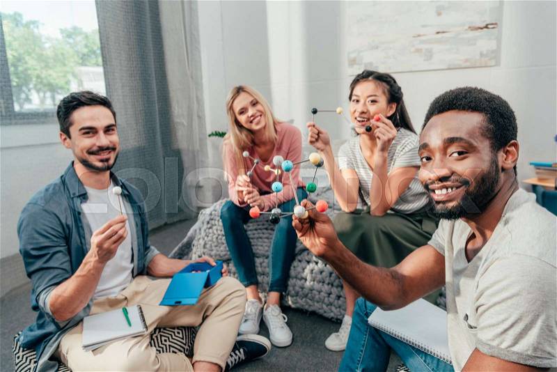 Group of young happy students studying at home and looking at camera, stock photo