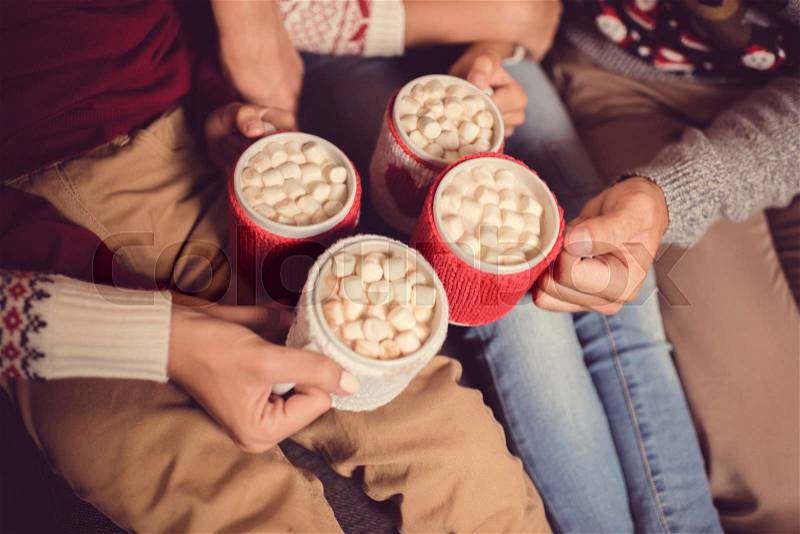 Partial view of family holding cups of cacao and marshmallow, stock photo