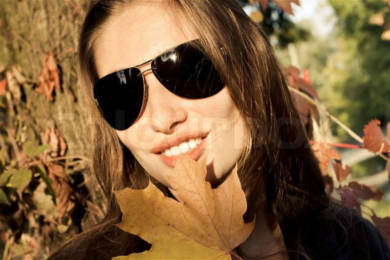 Beautiful girl smiling at the background of the autumn woods, stock photo