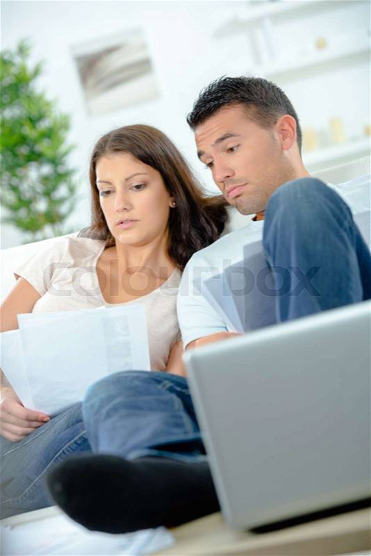 Couple with financial documents and laptop, stock photo