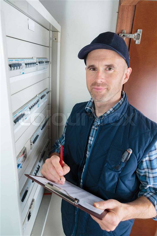 Engineer worker in front of fuse switch board, stock photo