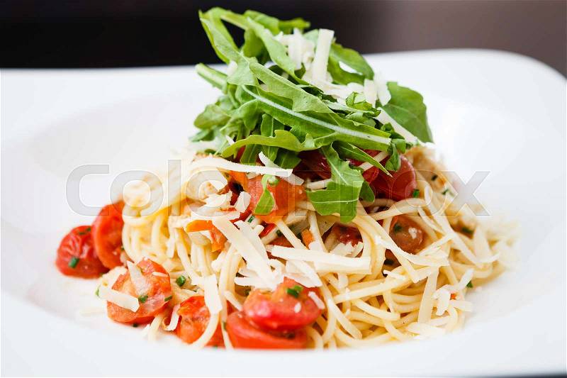 Classical chicken pasta with ruccola, tomatoes and cheese, stock photo