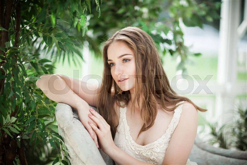 Nice Young Woman Fashion Model Relaxing in Green Leaves, stock photo