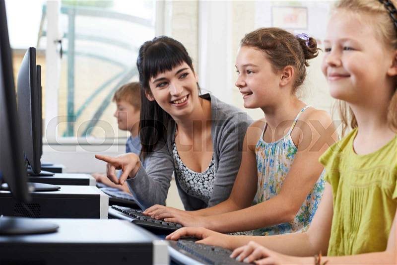 Female Elementary Pupil In Computer Class With Teacher, stock photo