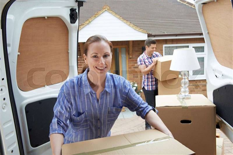 Young Couple Moving In To New Home Unloading Removal Van, stock photo