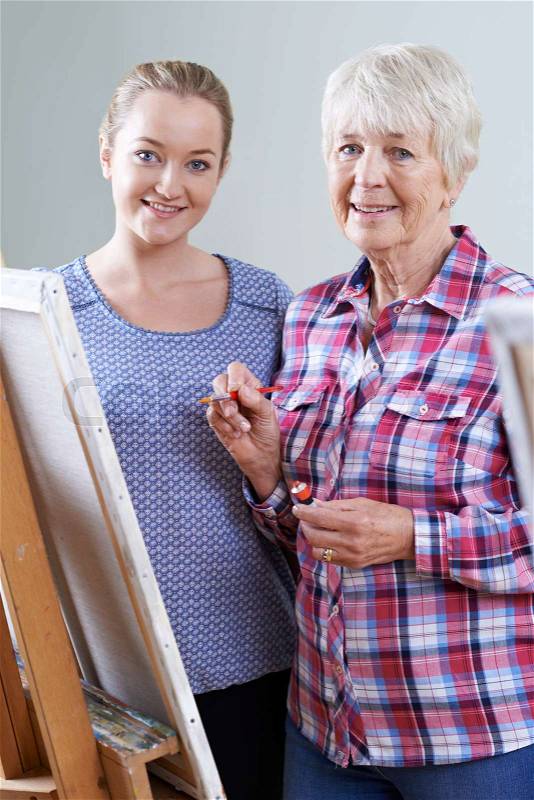 Senior Woman Attending Painting Class With Teacher, stock photo
