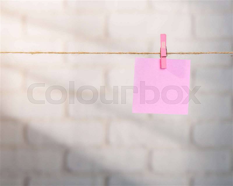 Wooden clothespin and blank paper on a rope against white brick wall,TODAY letters, stock photo
