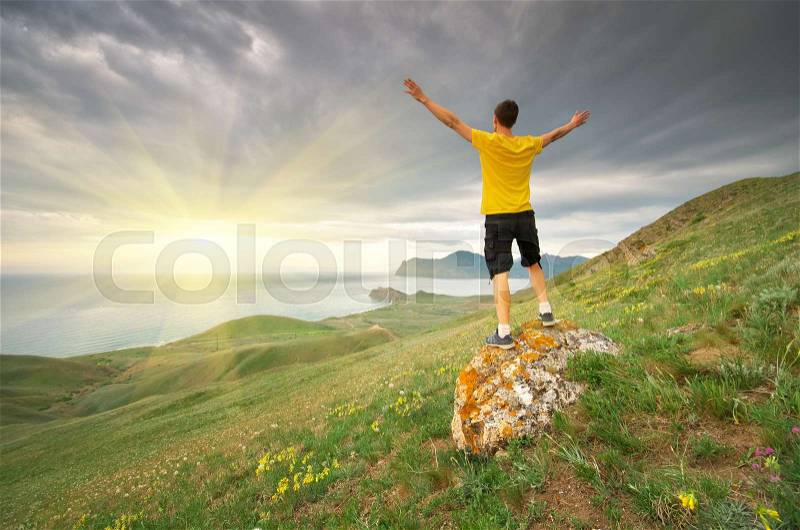 Man rising to sun. Mountain and sea nature. Conceptual design, stock photo