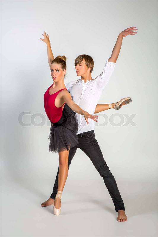 Beautiful ballet couple. ballerina in black tutu skirt. man in jeans and white shirt. studio shot. copy space, stock photo