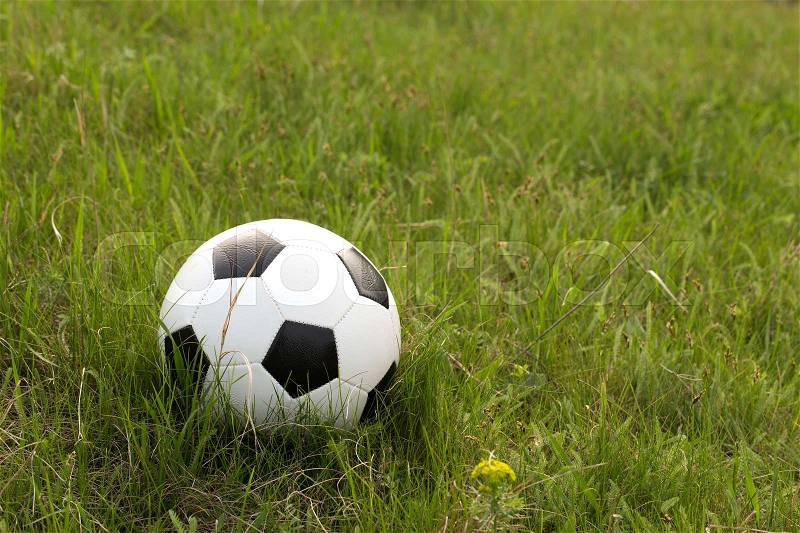 Football and the green hill. Ball is situated on the grass, stock photo