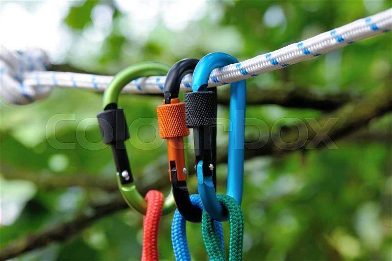 Carabiner with rope on nature background. Climbing uquipment.Climbing sports image of a carabiner on a rope, stock photo