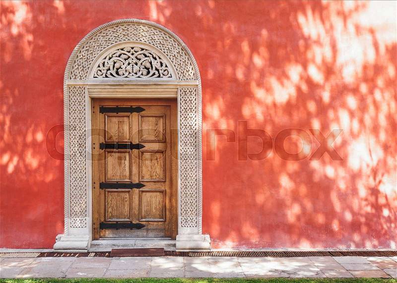 Zica monastery, 13th century, carved medieval stone door in the red stucco wall, architecture detail, stock photo