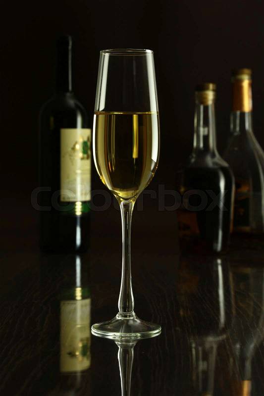 Wine glass and Bottle on a black mirror background, stock photo