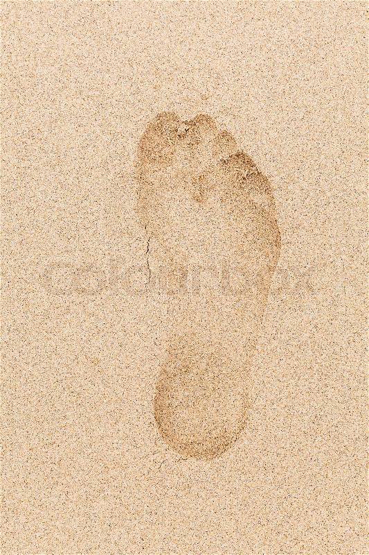 Human footprint in wet yellow sand on the beach, stock photo