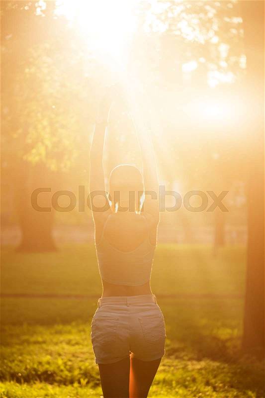 Silhouette of female model in sunlight in park. breathing fresh air outdoors. Healthy active lifestyle concept. portrait of happy sporty woman relaxing in park, stock photo