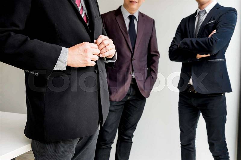 Group of business people with businessman leader standing with arms folded on foreground, stock photo