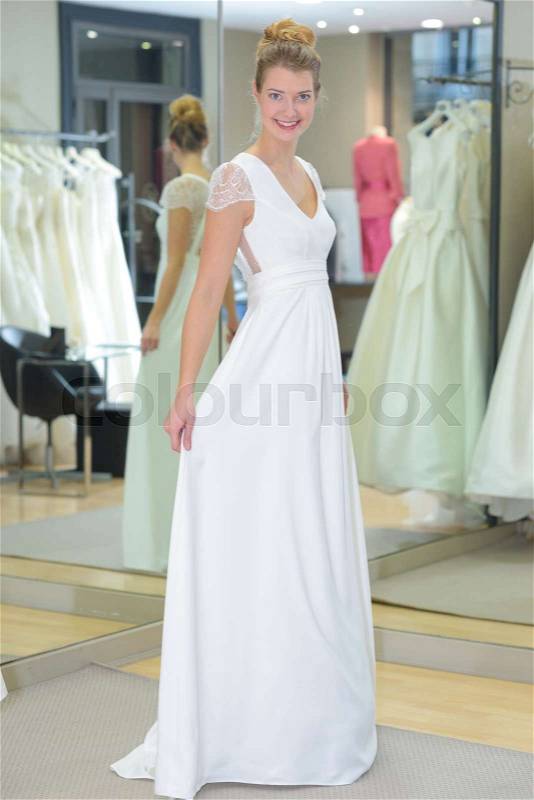 Youn happy bride looked at her wedding dress, stock photo