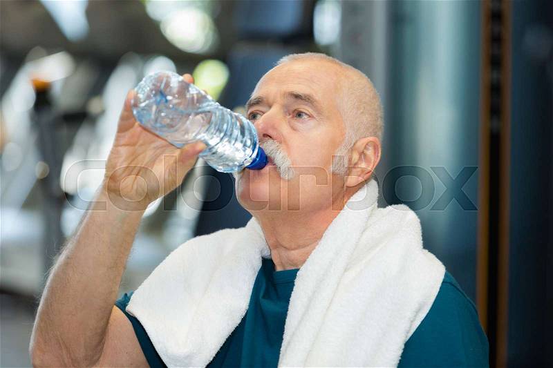 Old man with towel and drinking water, stock photo