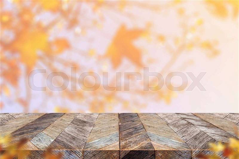 Empty old rustic wood plank table top with blur maple leaf with sunlight and blurred leaf at foreground,Autumn backgorund,Mock up for display or montage of product,banner for advertise on online, stock photo