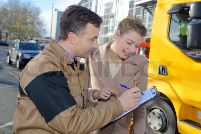 Mixed race woman receiving package from delivery man, stock photo