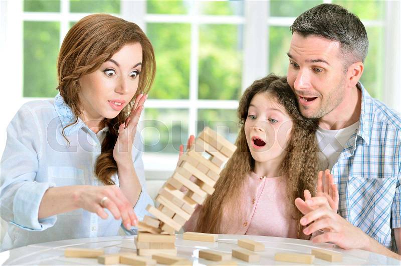 Portrait of happy family playing with wooden blocks, stock photo