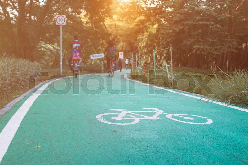 Bicycle symbol on street with people cycling in the park, stock photo