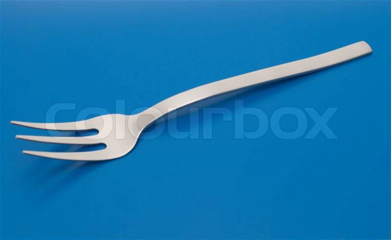 Fork for meat carving isolated on the blue background, stock photo