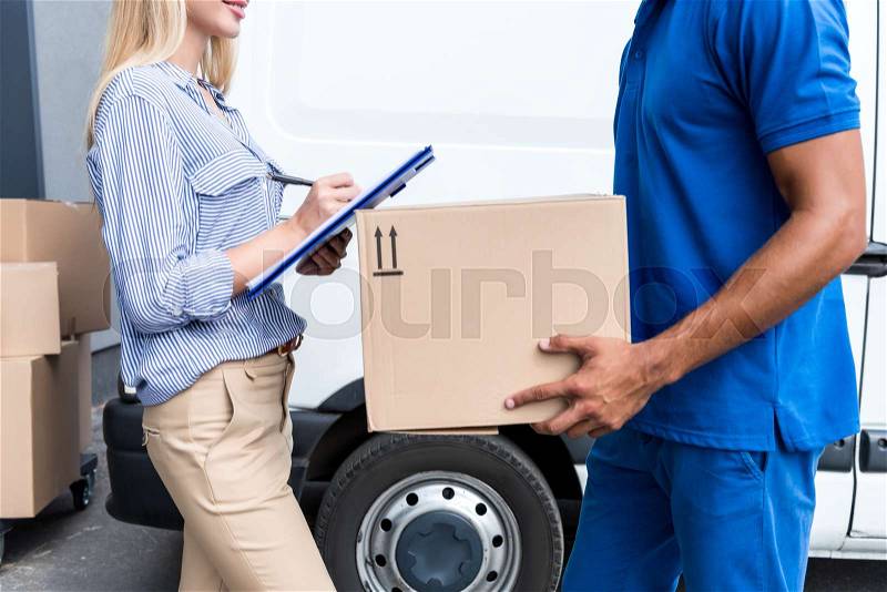 Cropped shot of courier delivering packages for woman, stock photo