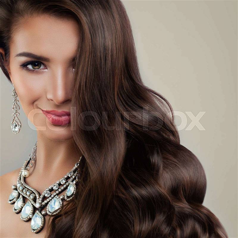 Perfect Woman Fashion Model with Diamond Earrings and Jewelry Necklaces. Beautiful Lady with Makeup and Curly Hair, stock photo