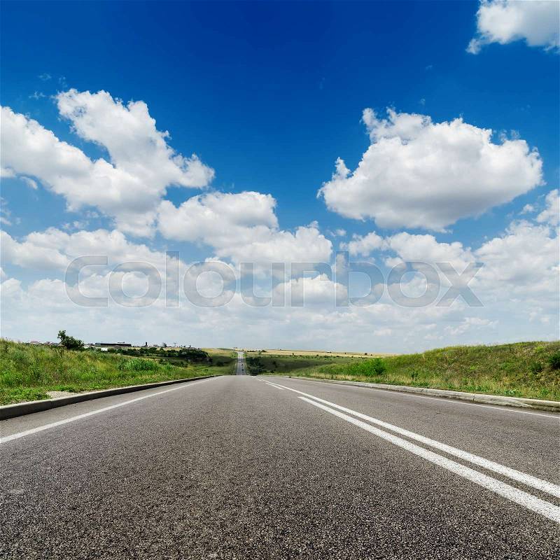 Asphalt road to horizon and deep blue sky with white clouds, stock photo