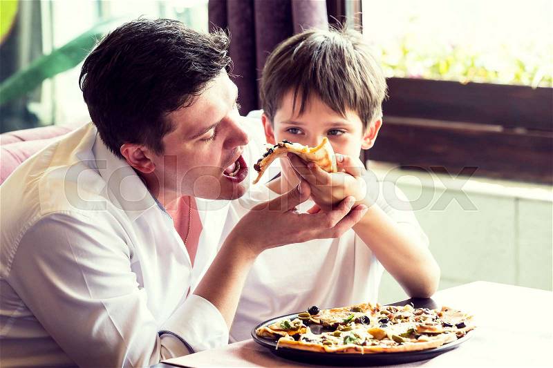 Father son eating an Italian pizza, stock photo