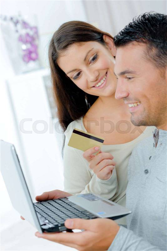 Happy couple buying on line with a credit card, stock photo
