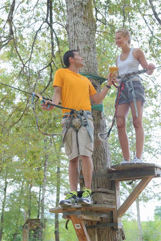 Family on a rope climbing in the adventure park, stock photo
