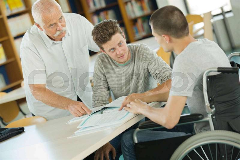 Young wheelchair user working on a laptop, stock photo