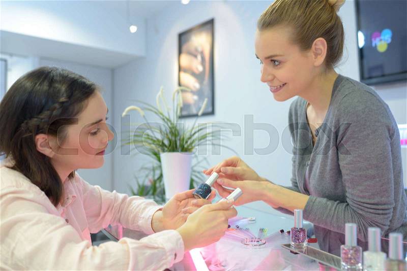 Woman choosing new nail polish color at store, stock photo
