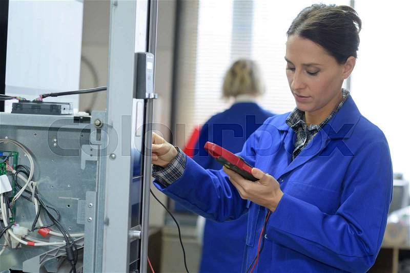 Smiling technician analysing server in large data center, stock photo