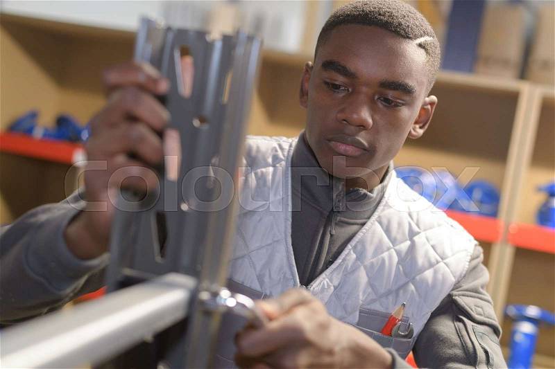 Young african carpenter working in workshop, stock photo