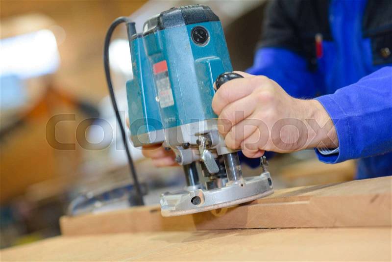 Electric sander carpenter sanding a wood with sander, stock photo