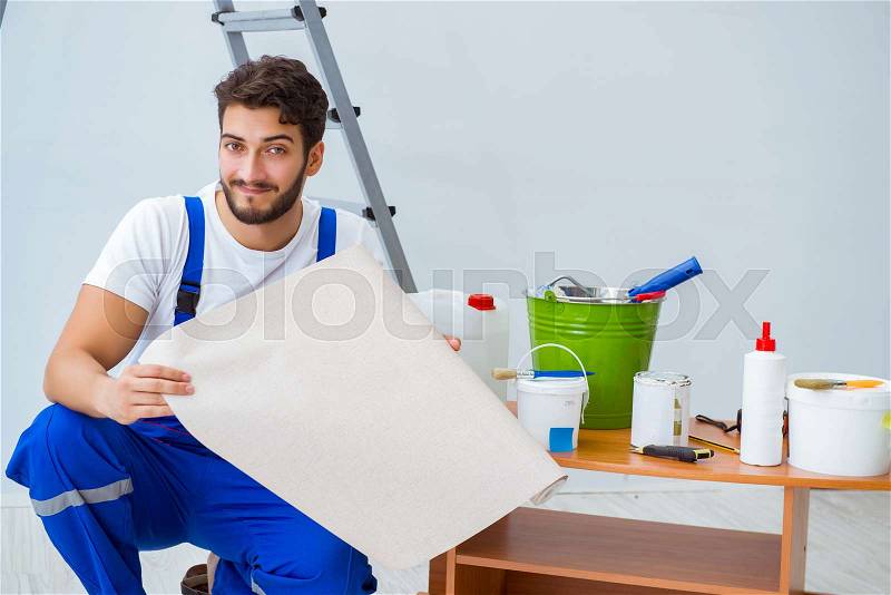 Repairman doing renovation repair in the house with paper wallpaper, stock photo