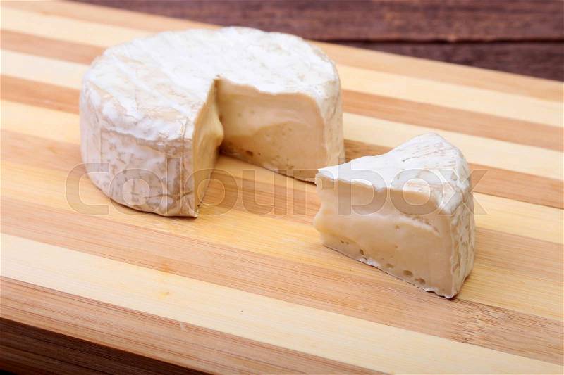 Cheese with white mold. Camembert or brie type on wood table. Healthy breakfast, stock photo