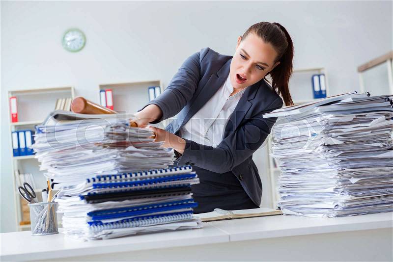 Angry businesswoman with baseball bat in office, stock photo