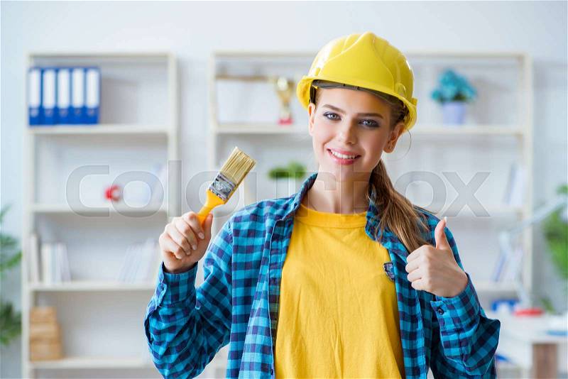 Woman painter with paintbrush in workshop, stock photo