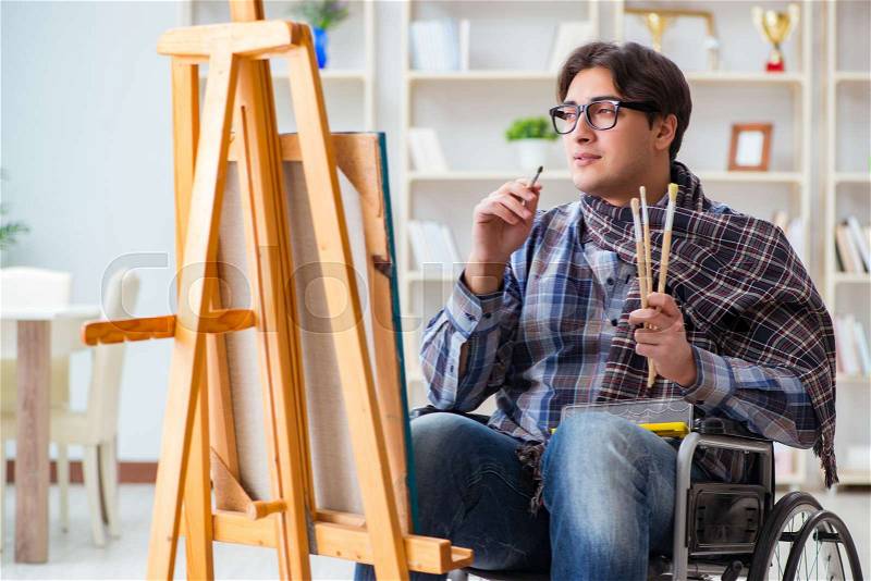 Disabled artist painting picture in studio, stock photo